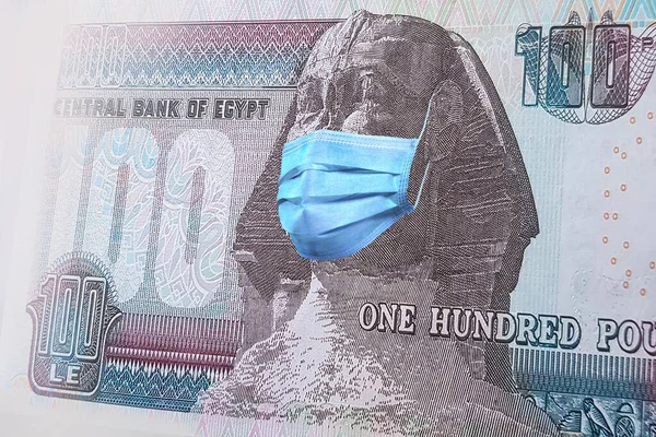 Mısır 'daki koronavirüs salgınının Sfenksi üzerinde tıbbi bir maskeyle 100 banknot. Coronavirüs salgınının Mısır ekonomisi üzerindeki etkisi. Coronavirüs salgınının etkileri