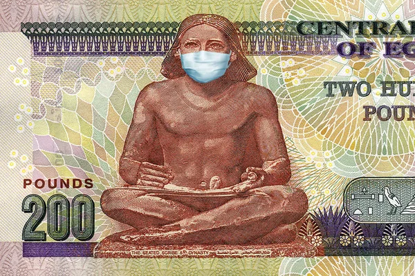 Mısır 'daki koronavirüs salgınının tıbbi maskesiyle birlikte 200 banknot. Coronavirüs salgınının Mısır ekonomisi üzerindeki etkisi. Coronavirüs salgınının etkileri