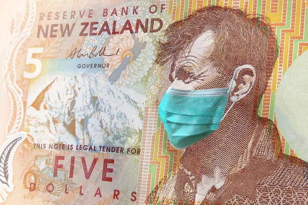new Zealand 5$ banknotes with a medical mask. the coronavirus epidemic in new Zealand. the impact of the coronavirus epidemic on the new Zealand economy