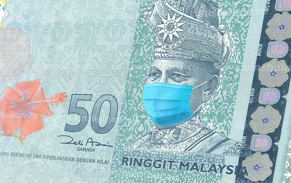 Malezya 'da 50 Ringgit banknotu tıbbi maske koronavirüs .salgını Malezya' da. Virüs salgınının Malezya ekonomisi ve para birimi üzerindeki etkisi