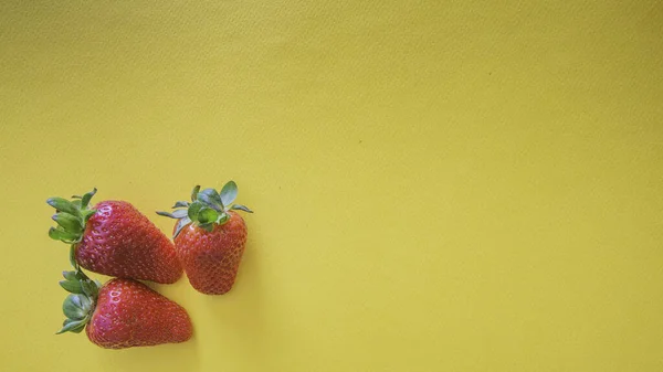 Fondo Tarjeta Amarilla Tres Pequeñas Fresas Rojas Parte Inferior Izquierda — Foto de Stock