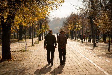 Bitola / Kuzey Makedonya - 02.19.2020: Yaşlı emekliler şehir parkında huzur içinde yürüyor