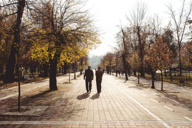 Bitola / Kuzey Makedonya - 02.19.2020: Yaşlı emekliler şehir parkında huzur içinde yürüyor