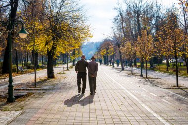 Bitola / Kuzey Makedonya - 02.19.2020: Yaşlı emekliler şehir parkında huzur içinde yürüyor