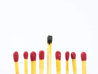 Bir kullanılmış kibritle sekiz taze kibrit çöpü tek sıra halinde ve beyaz arka plan üzerinde izole edilmiş.