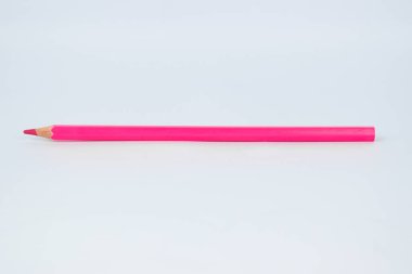 İzole edilmiş beyaz bir arka plana yerleştirilmiş tek pembe, keskin tahta kalem.
