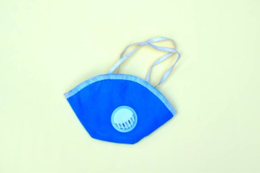 Kauçuk kayışlı açık mavi kirlilik maskesi ve beyaz arka planda izole edilmiş plastik havalandırma.
