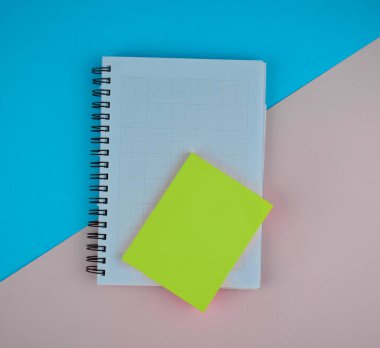 Mavi-pembe kağıt arkaplanından önce beyaz kağıt günlüğün üzerine açık yeşil yapışkan notlar.