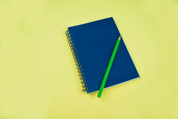 簡単な青いノートの本の上にライトグリーンの書き込み鉛筆クレヨン書く準備ができて — ストック写真