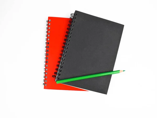 在白色底色前 在两本不同颜色的笔记本上贴上一支绿色木制铅笔笔的近景 — 图库照片
