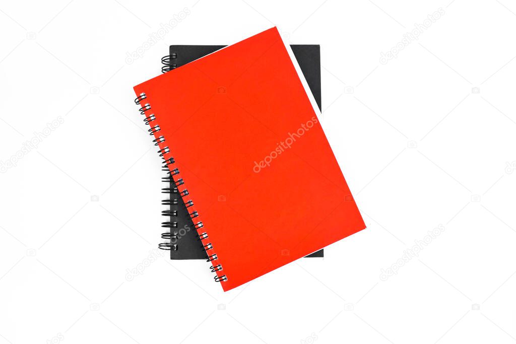 Couple of paper note diary of red and black color placed on top of each other before a white background