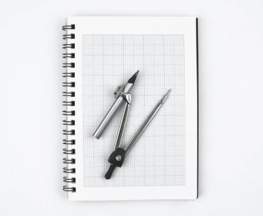 Beyaz kağıt bir günlüğün üzerine yerleştirilmiş gümüş bir kaleme bağlı bir kalem pusulası.