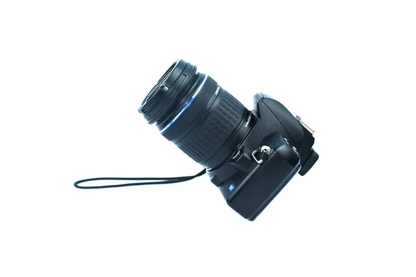 Üzerinde lens olan tek bir dijital kamera beyaz izole edilmiş bir arkaplan üzerine yerleştirilmiş.