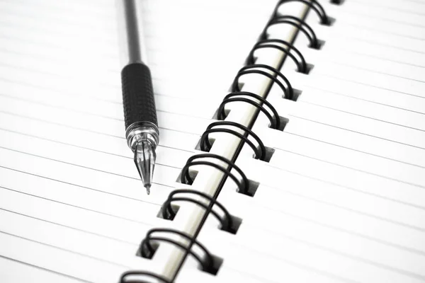 白い背景にシンプルな白い紙の日記の上に置かれた暗い黒い色のペン — ストック写真