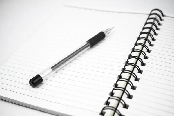 白を基調としたシンプルな白い紙の日記の上に置かれた単色の黒ペン — ストック写真