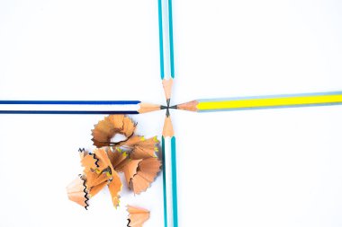 Dört farklı renkte tahta kalem kalemi hepsi ortadaki bir noktayı işaret ediyor.