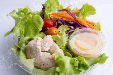 Beyaz arka planda domatesli tavuk fileto ile taze salata.