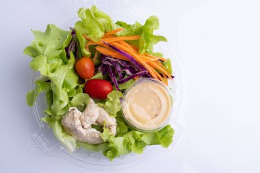 Beyaz arka planda domatesli tavuk fileto ile taze salata.