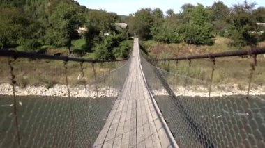 Güzel bir dağ nehri üzerinde ahşap bir köprü.