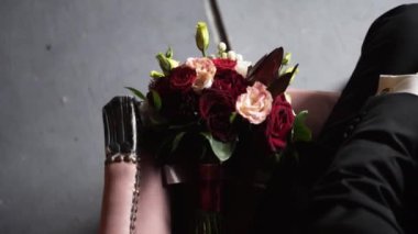 Güzel bir buket kırmızı gül, karanlık bir odada bir kanepede duruyor..