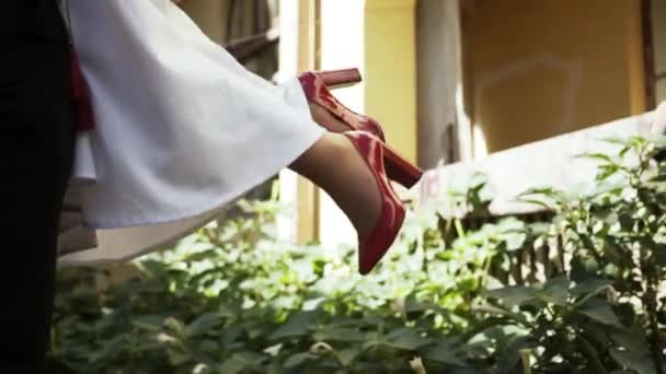 Homem Segura Uma Menina Seus Braços Usando Sapatos Vermelhos — Vídeo de Stock