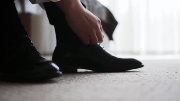Homme Assis Sur Canapé Pantalon Gris Met Des Chaussures Noires — Video