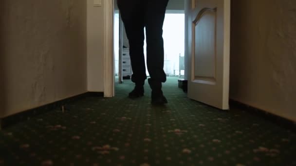 男は緑のカーペットと狭い廊下に沿って歩いて クローズアップ — ストック動画