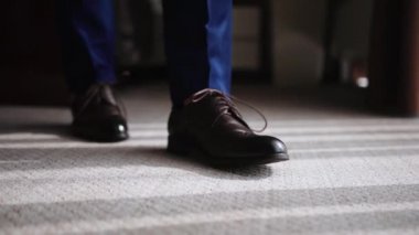 Kahverengi deri ayakkabılar, yakın plan, bir adam pencerenin yanında duruyor..