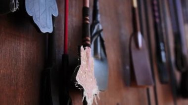 Tahta kapıya asılı at kırbaçları