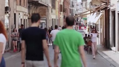 Bir İtalyan kasabasında sıcak bir yaz gününde işlek dar bir cadde