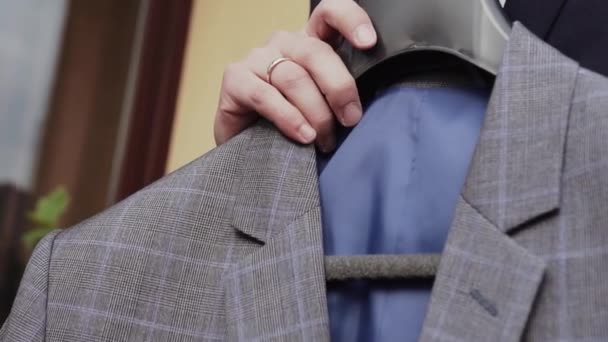 Hombre Sostiene Traje Gris Sus Manos — Vídeo de stock