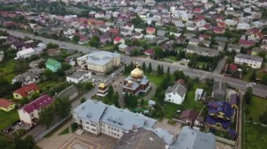 Küçük güzel evleri, doğası, geniş yolu ve merkezinde altın kubbeleri olan bir kilisesi olan kuadkopter drone 'dan samimi bir şehir manzarası.
