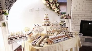 Büyük, güzel, parlak bir açık büfe, bir sürü tatlı atıştırmalık, bir çikolata, beyaz bir masanın üzerinde ve kutlamada misafirleri bekliyor. Yan görünüm.