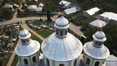 Küçük bir köydeki mezarlığın yanında duran büyük beyaz bir kilisenin havadan görünüşü. Yukarıdan bak. Kuş bakışı