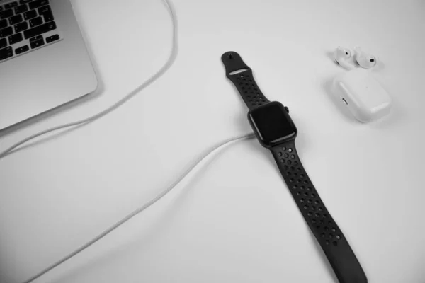Laptop saatin ve kulaklığın yanındaki masada. Mobil ofis işi için gereken her şey.