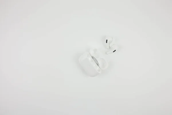 Wireless white earphones on a white background.