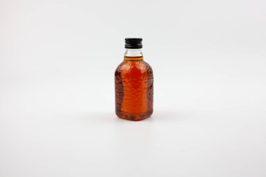 Rom 'a benzeyen küçük bir şişe kahverengi sıvı. Hint romu.