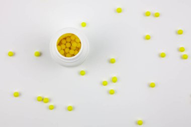 Beyaz arka planda ambalajı olan sarı haplar. Vitaminli sağlıklı yaşam tarzı.