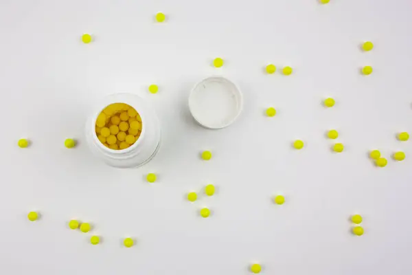 Beyaz arka planda ambalajı olan sarı haplar. Vitaminli sağlıklı yaşam tarzı.
