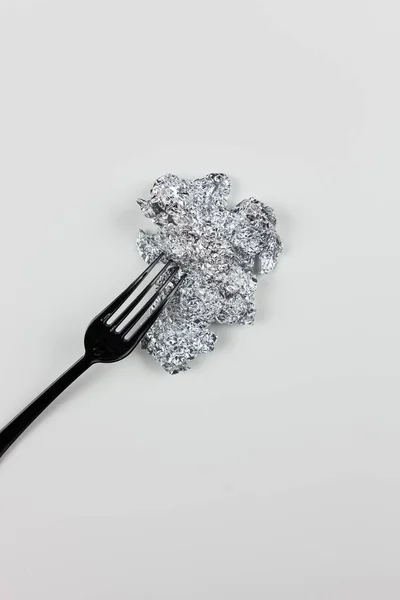 Beyaz arka planda siyah plastik çatal ve metal folyo. Çeşitli materyallerin sunumu için. Çöp işleme.