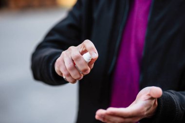 Eller yakın çekim, adam ellerine dezenfektan sürüyor. Genç bir adam kendini koronavirüsten korumak için elinde dezenfektan sıvısı tutuyor. Covid 2019.