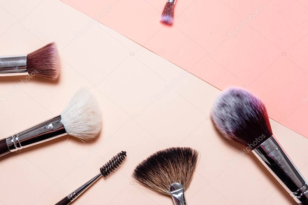 Flat top view set of professional brushes on a light background. Copy space for your text. Makeup brushes on a bright background. Aerial view of various brushes. Various sizes of makeup brushes.