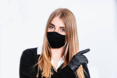 Makyaj yapan güzel bir genç kadın. Yüzüne pudra sürmek için elinde fırça olan bir kız. Siyah eldivenli kadın makyaj yapar. Kadın beyaz arka planda makyaj yapıyor..