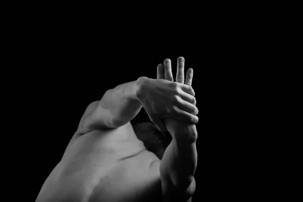 Kaslı, seksi vücutlu ve sırtı çıplak bir erkek sporcu. Adam geri döndü ve elleri siyah bir arkaplanda. Sırtı ve kolları şişmiş..