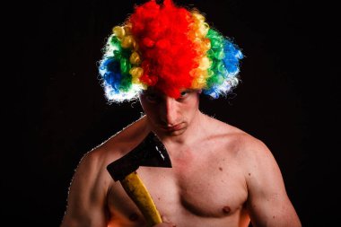 Elinde balta olan çılgın bir palyaço. Baltalı palyaço. Çılgınca. Psikopat. Siyah arka planda baltalı çılgın bir adam..