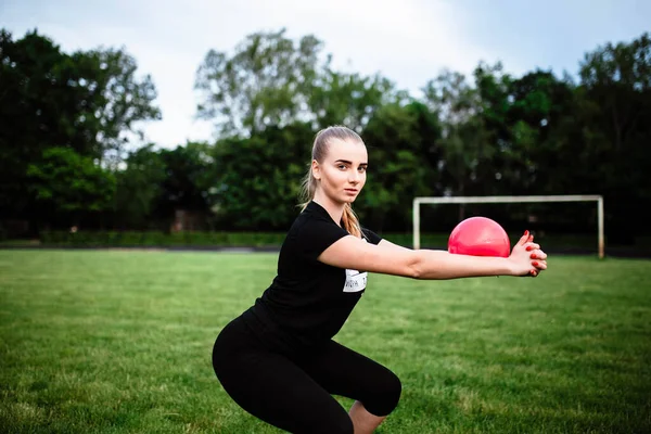 健康的运动生活方式 穿着运动服做运动锻炼的年轻女子 体育馆的健身女士 年轻女子蹲伏 这个年轻姑娘参加体育活动 — 图库照片