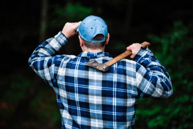 Ormanda çalışan bir oduncu. Yaz ormanında baltası olan oduncu. Oduncu elinde bir balta tutuyor. Oduncu sırtında bir balta tutuyor. Oduncu sınıfa gösterir. Balta elinde..