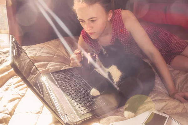 girl with black cat working on the computer
