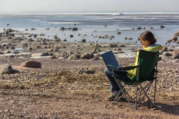 girl working on a computer in nature