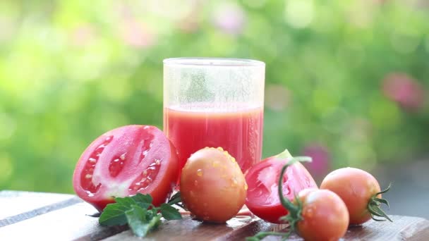 Zumo de tomate y tomates frescos en el jardín en verano — Vídeos de Stock